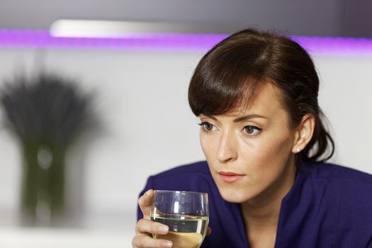 Smart business woman relaxing in her kitchen with a glass of wine.