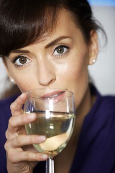 Smart business woman relaxing in her kitchen with a glass of wine.