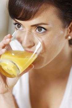 Beautiful young woman enjoying a glass of juice.