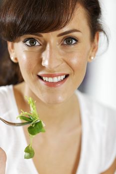 Young woman enjoying a fresh salad in her kitchen