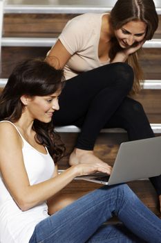 Two friends studying together on a staircase.