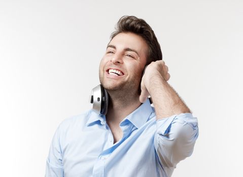 excited man in blue shirt with earphones listening to music