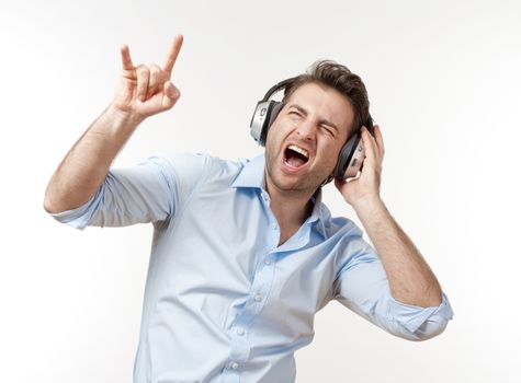 excited man in blue shirt with earphones listening to music