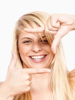 young girl looking through a finger frame smiling - isolated on white