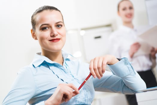 portrait of a business woman in office, smiling and looking into the camera, office work