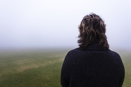 Woman Unidentified looks into the season mist over the field pending future days.