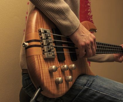 Man sitting and playing a bass guitar (Series with the same model available.)