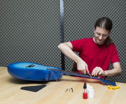 Guitar technician cutting the old strings away ( Series with the same model available)