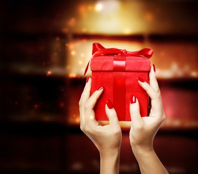 Woman displaying red present box on Christmas
