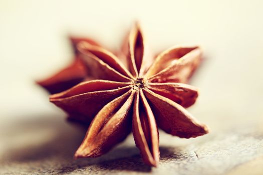 Two star anise on rustic wooden board