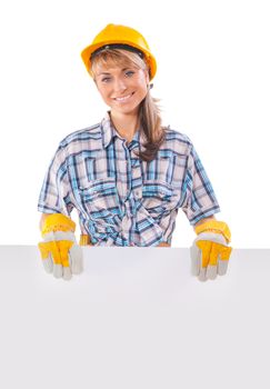 Smiling happy young female construction worker with white placard isolated on white background