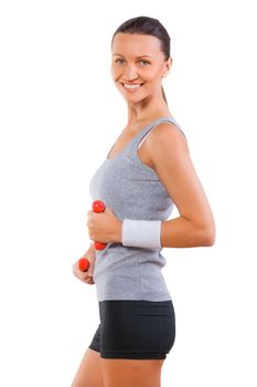 Sportswoman smiling holding small dumbbells isolated on white background
