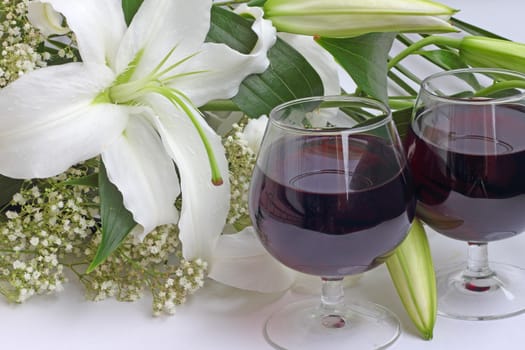 Wine and flowers on white background