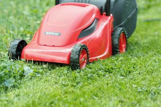  new lawnmower on green grass in cloudy day