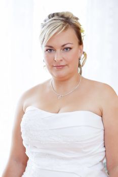 home portrait of beautiful smiling bride weared to white clothe
