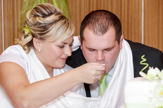 tradition, bride feeding her groom with spoon on wedding lunch