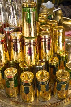 Traditional Moroccan tea glasses on display on a street market stall