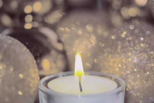 Close-up of christmas baubles and candle light