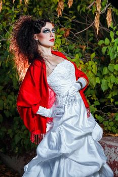 Attractive bride in a wedding dress with bright makeup, red shawl