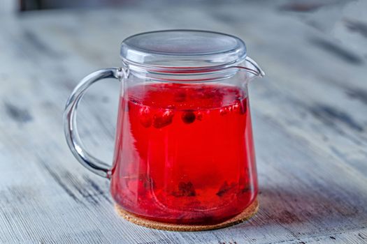 Glass tea kettle on the wooden table closeup shot