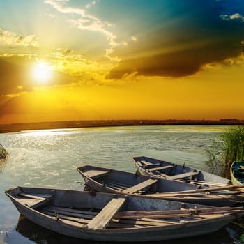 yellow sunset over river with boats