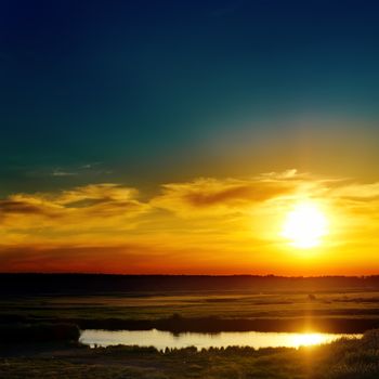 blue and orange sunset over lake