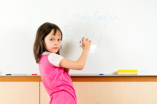 Young girl by a whiteboard at school