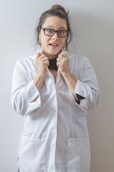 thirtie something brunette woman wearing a lab coat holding up her collar