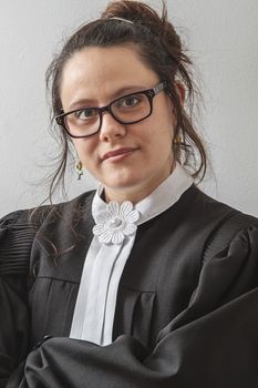 thirtie something brunette woman wearing a canadian lawyer toga with her arm folded