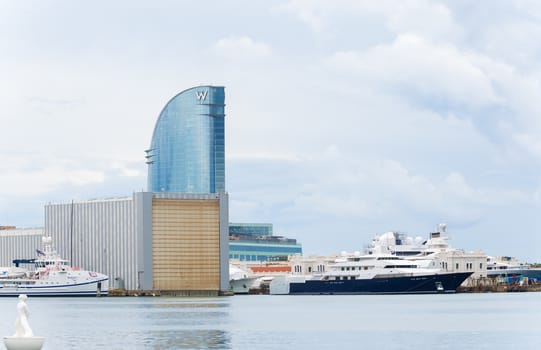 Barcelona, Spain - October 17, 2013: View at the Port and W Barcelona, popularly known as the Hotel Vela (Sail Hotel) due to its shape.It  is a building designed by Ricardo Bofill is located in the Barceloneta district of Barcelona, in the expansion of the Port of Barcelona. 