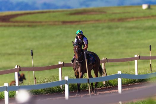 Jockey riding race horse galloping on sand track training