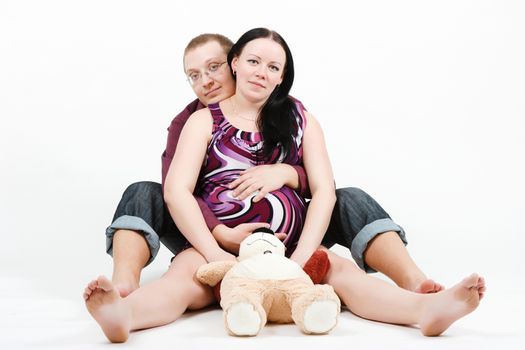 Young happy couple. Husband and pregnant wife. studio photography