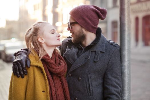 Young smiling happy hipster couple hugging in winter