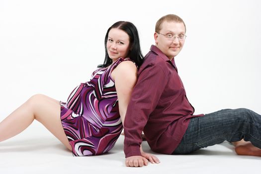 Young happy couple. Husband and pregnant wife. studio photography