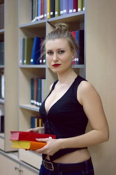 Beautiful sexy woman with naked torso. She is posing in library
