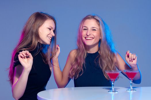 Happy beautiful girls with a drink in nightclub