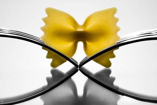 Farfalle pasta held by two forks.