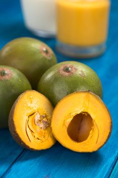 Peruvian fruit called Lucuma (lat. Pouteria lucuma) which has a dry, sweet flesh, and is mostly used to prepare juices, milkshakes, yogurts, ice cream and other desserts (Selective Focus, Focus on the upper right part of the right lucuma half) 