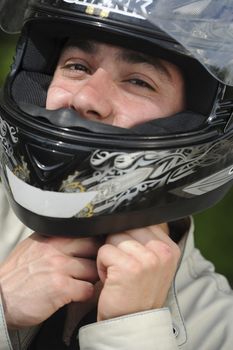 Young man with motorcycle putting the helmet