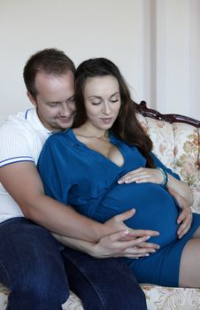 Happy beautiful pregnant woman with his husband at home