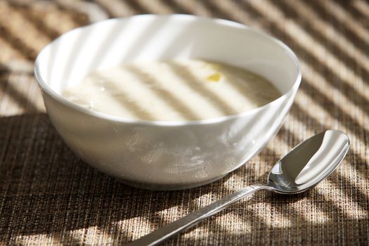 Breakfast in the sunny morning. Oatmeal porridge in white bowl