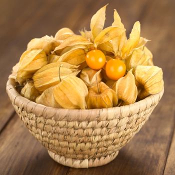 Physalis berry fruits (lat. Physalis peruviana) with husk in basket (Selective Focus, Focus on the open physalis)