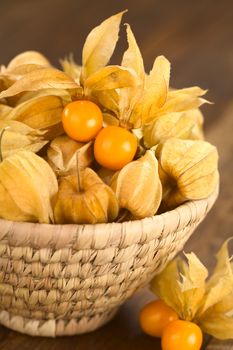 Physalis berry fruits (lat. Physalis peruviana) with husk in basket (Selective Focus, Focus on the open physalis berries in the basket)