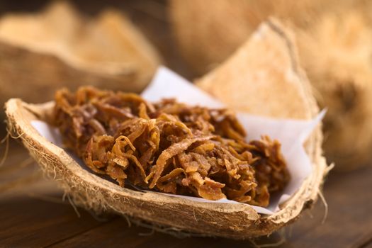 Peruvian cocada, a traditional coconut dessert sold usually on the streets, made of grated coconut and brown sugar, which gives the dark color of the sweet (Selective Focus, Focus on the front of the cocada)