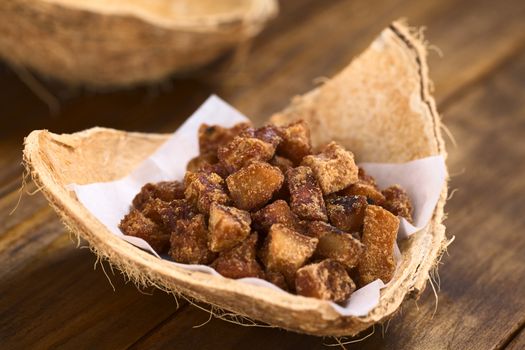 Peruvian coconut sweets sold usually on the streets, made of coconut pieces and brown sugar, which gives the sweet its brown color (Selective Focus, Focus in the middle of the sweets)