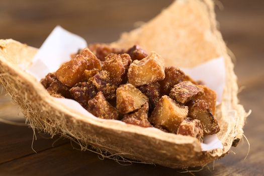 Peruvian coconut sweets sold usually on the streets, made of coconut pieces and brown sugar, which gives the sweet its brown color (Selective Focus, Focus on the sweets on the top)