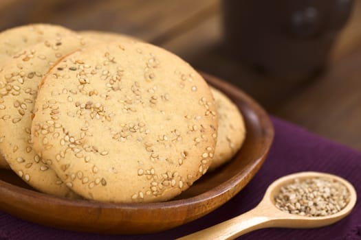 Sesame cookies on wooden plate (Selective Focus, Focus one third into the first cookie)  