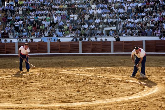 Pozoblanco, Cordoba province, SPAIN - 25 september 2011: Employees of the service from the plaza de toros de Pozoblanco smoothing the sand with a rake in Pozoblanco, Cordoba province, Andalusia, Spain