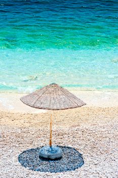 lonely beach umbrella casts a shadow