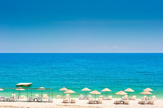 empty beach with white wicker umbrellas